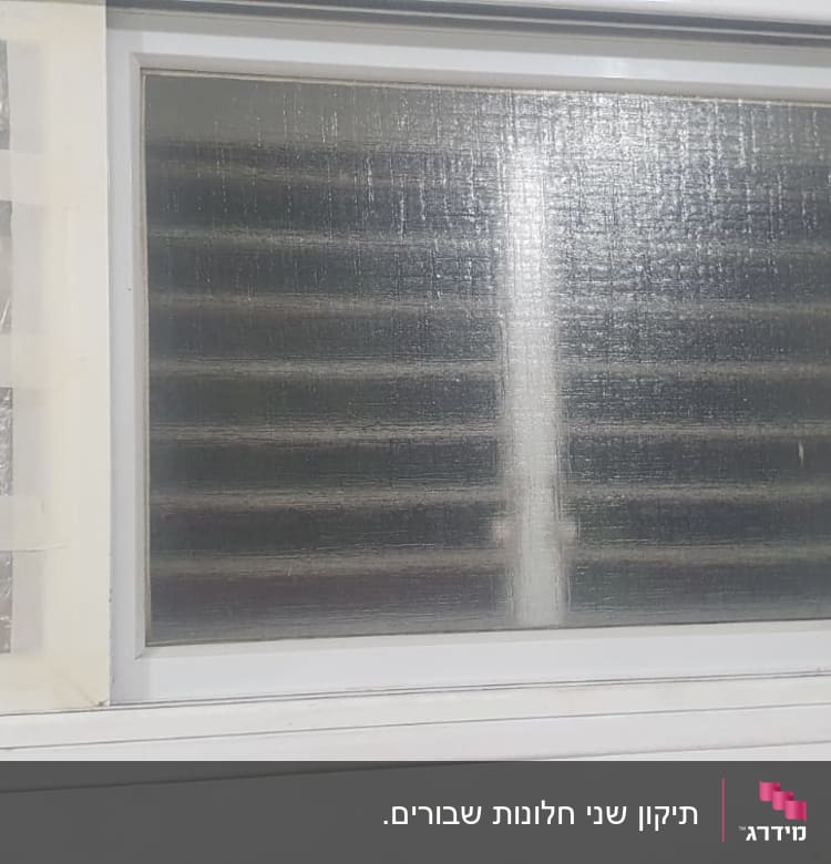 חלון זכוכית עם תריסים מאחוריו